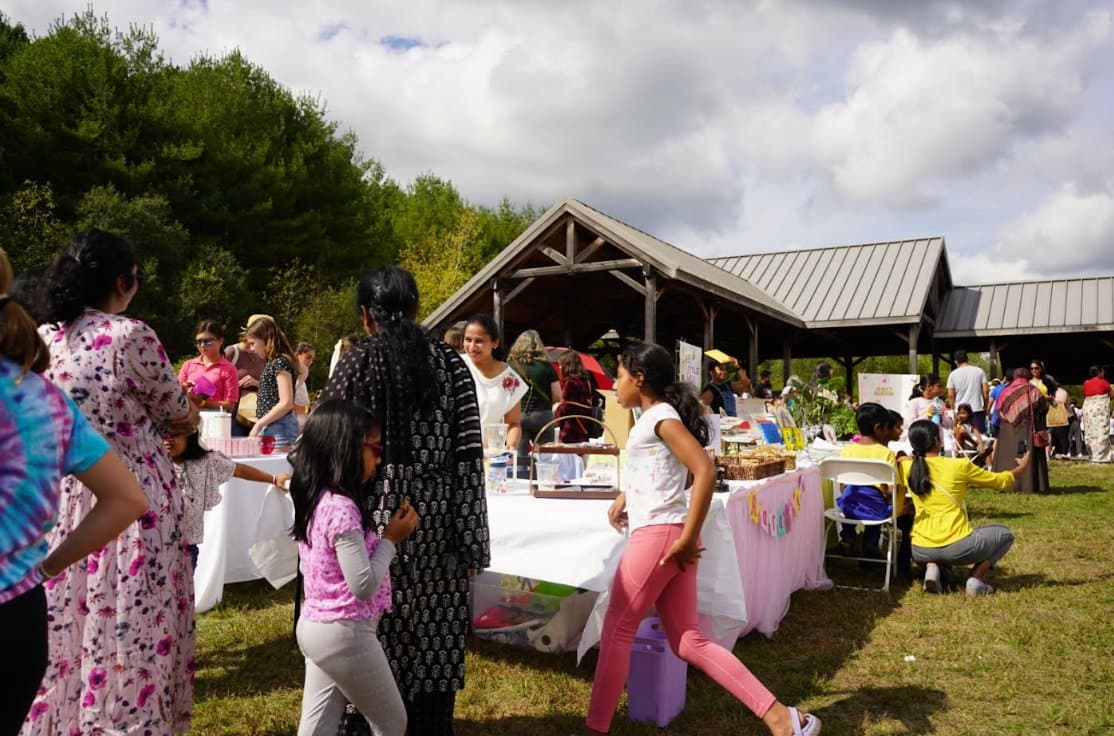 Full pavilion view of booths and families at the BASK Fair